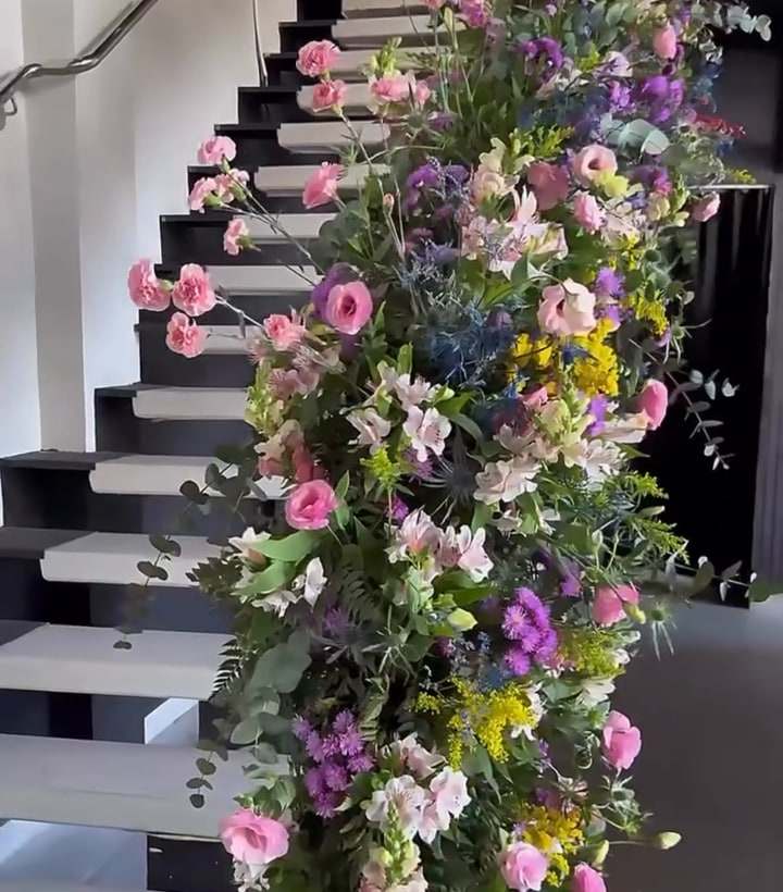 Escada do hall decorada com cascata de flores do chão ao mezanino