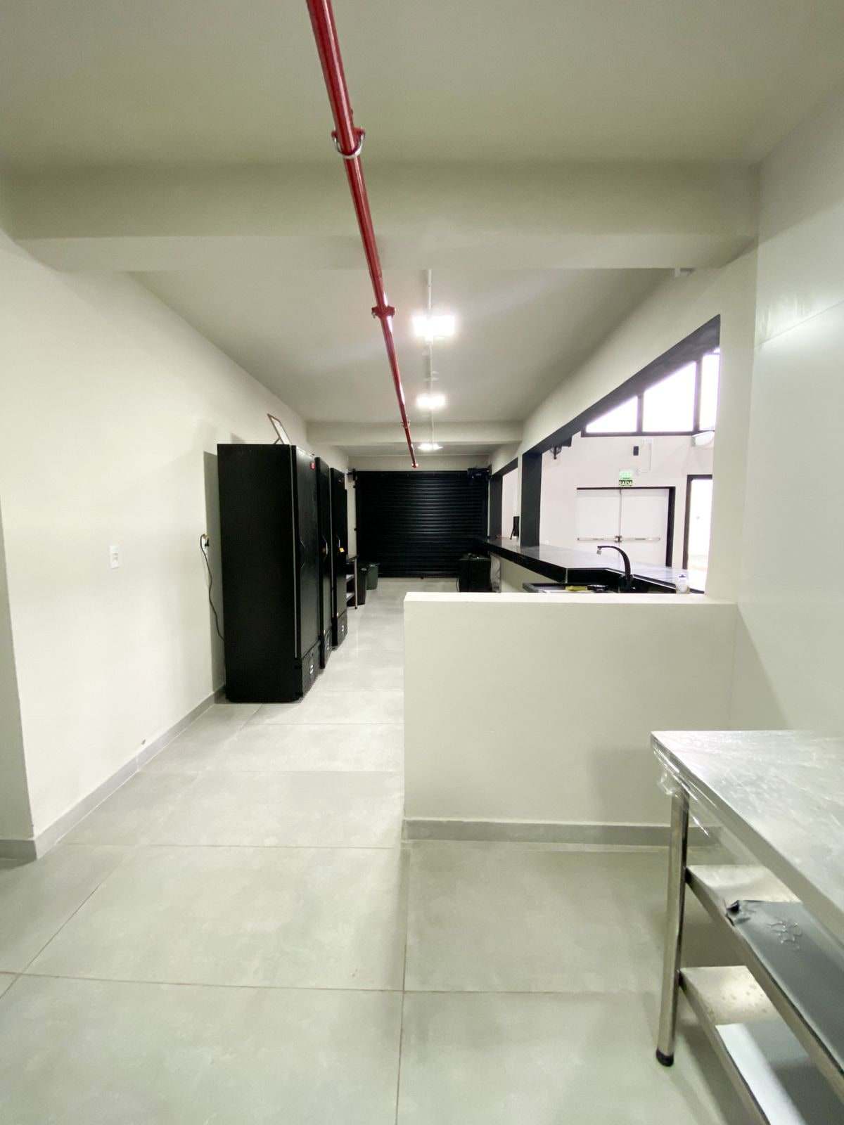 Cozinha de apoio para o buffet, com bancadas de inox e geladeiras