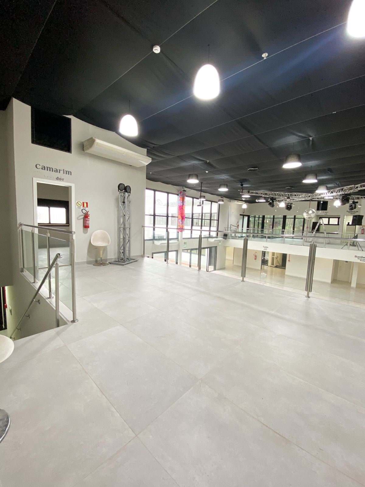 Palco superior com vista para o salão através do guarda-corpo de vidro
